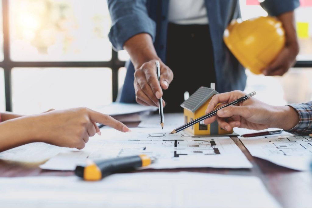 Ingenieur en bouwteam bespreken de stabiliteitsstudie voor een woningrenovatie.